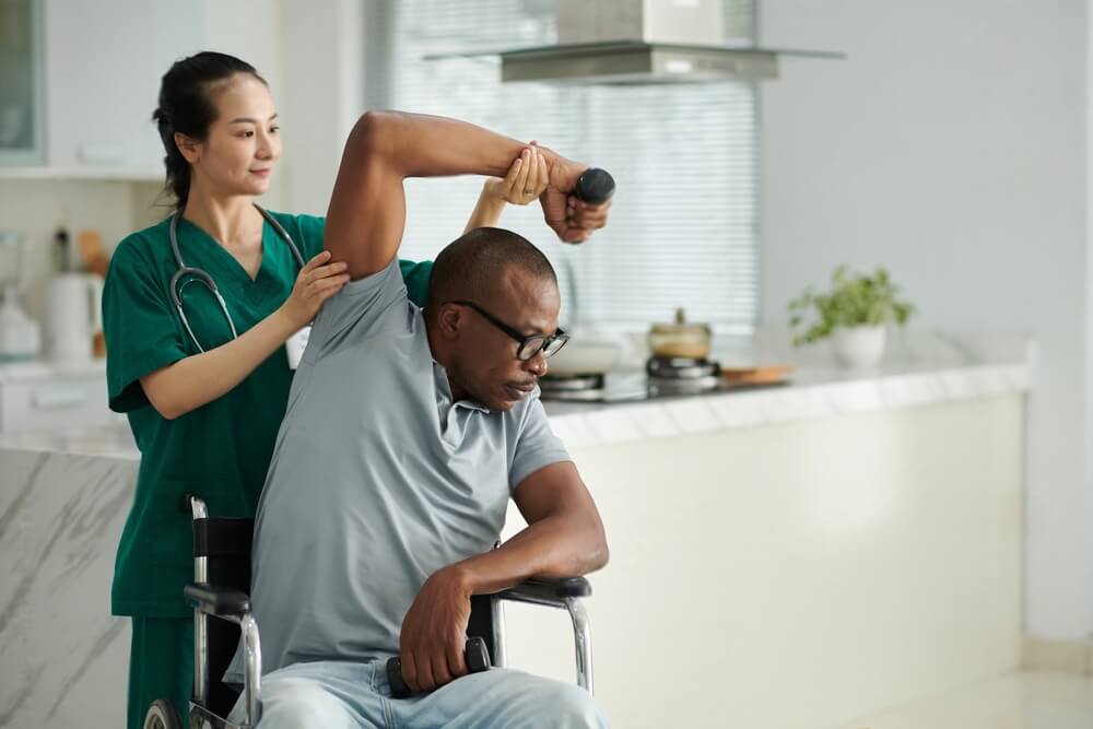 Physiotherapist asking patient to do side bend with dumbbell in hand